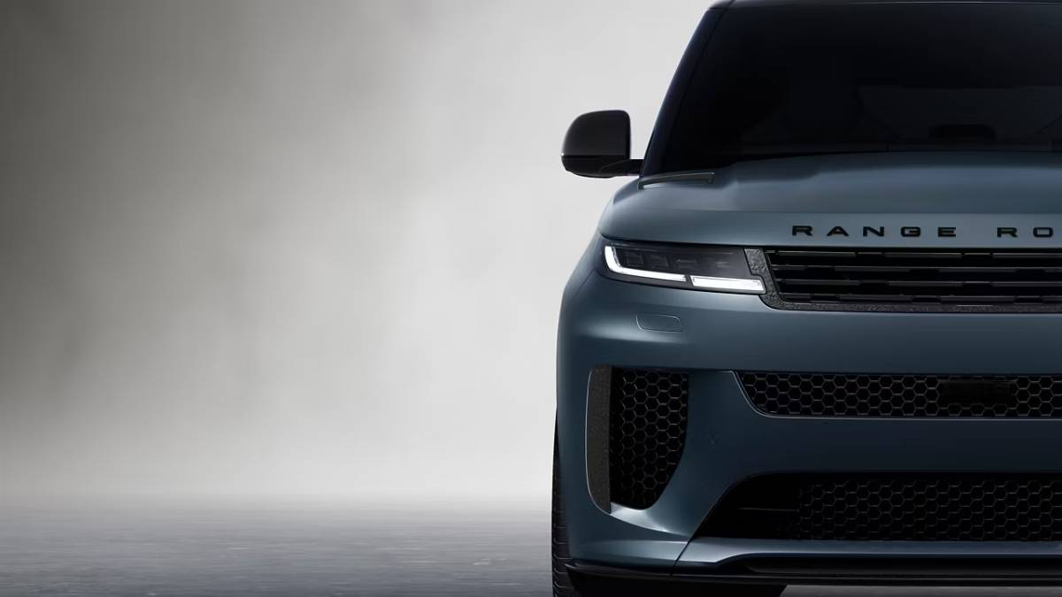 Front view of a sleek, modern Range Rover showcasing its stylish grille, bold headlights, and elegant design against a soft gray background.