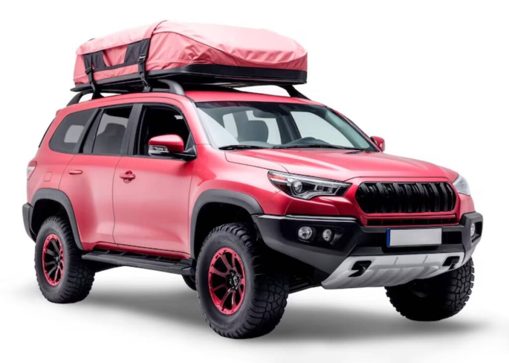 A vibrant red off-road SUV with a rooftop tent, rugged tires, and black accents, ready for adventure and exploration.