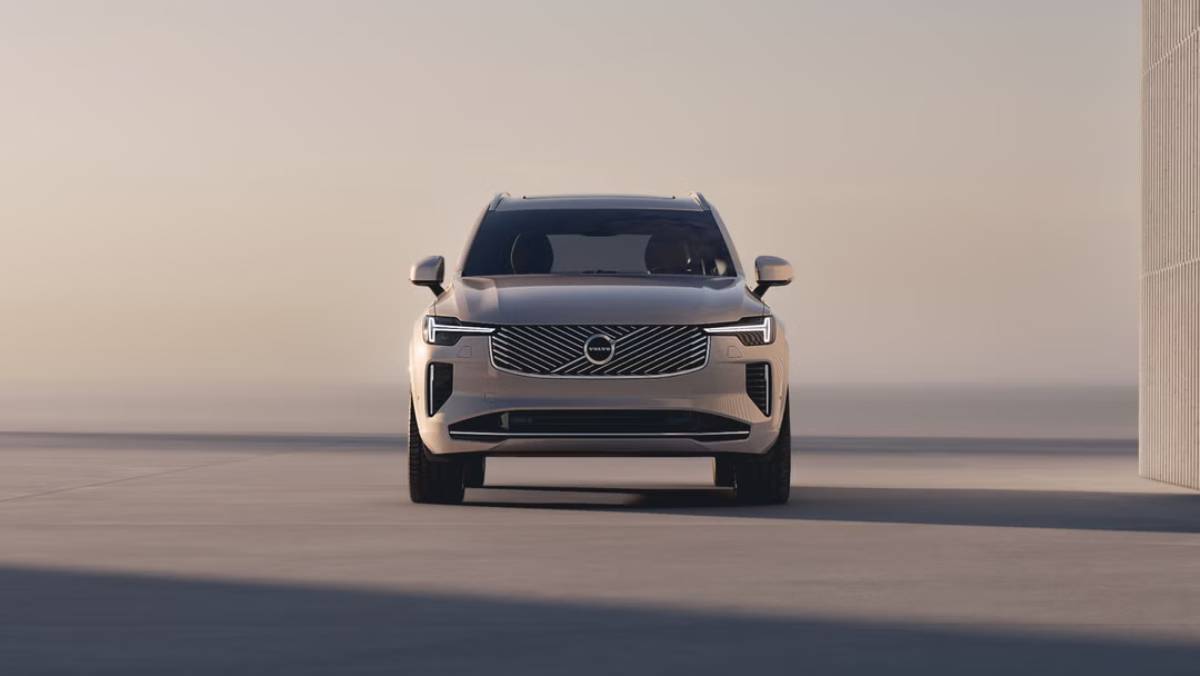 A sleek, modern Volvo SUV facing forward, featuring a prominent grille and LED headlights, against a soft, minimalistic background.